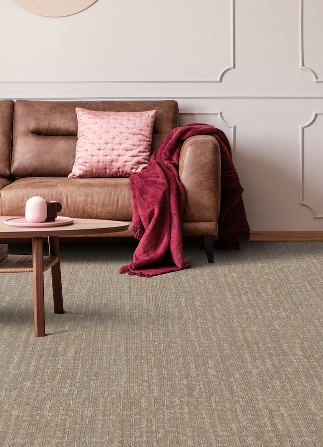 brown textured carpets in a living room with brown leather couch and pink accents